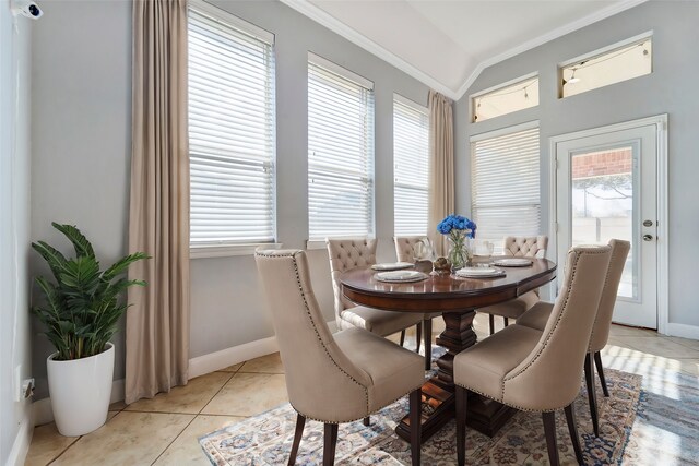 tiled dining room featuring vaulted ceiling, ornamental molding, and plenty of natural light