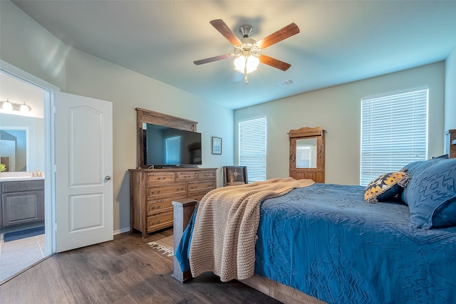 bedroom featuring ensuite bath, sink, dark hardwood / wood-style floors, and ceiling fan