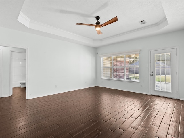 unfurnished room featuring dark hardwood / wood-style floors, a tray ceiling, and ceiling fan