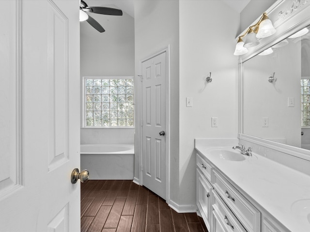 bathroom featuring vanity, a tub, wood-type flooring, and ceiling fan