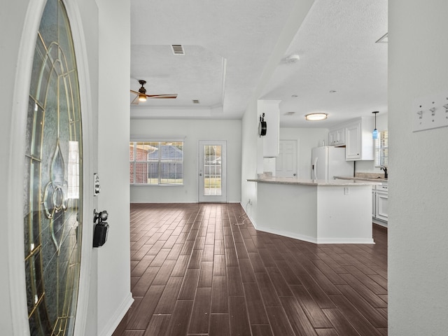 interior space featuring dark wood-type flooring, a textured ceiling, and ceiling fan