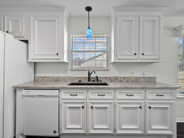 kitchen with a wealth of natural light, sink, white cabinets, and white appliances