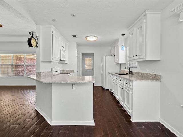 kitchen featuring white appliances, a healthy amount of sunlight, sink, kitchen peninsula, and white cabinetry