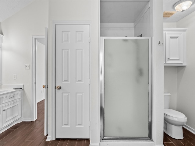 bathroom with a shower with door, toilet, hardwood / wood-style flooring, and vanity