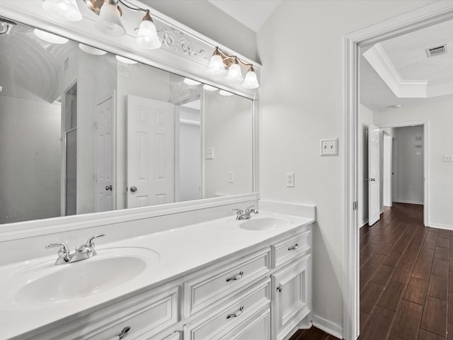 bathroom with vanity, crown molding, and hardwood / wood-style flooring