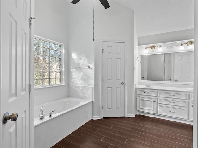 bathroom featuring vanity, a bathtub, hardwood / wood-style flooring, and ceiling fan