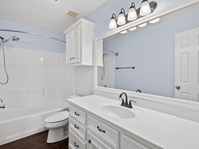 full bathroom featuring toilet, wood-type flooring,  shower combination, vanity, and a textured ceiling