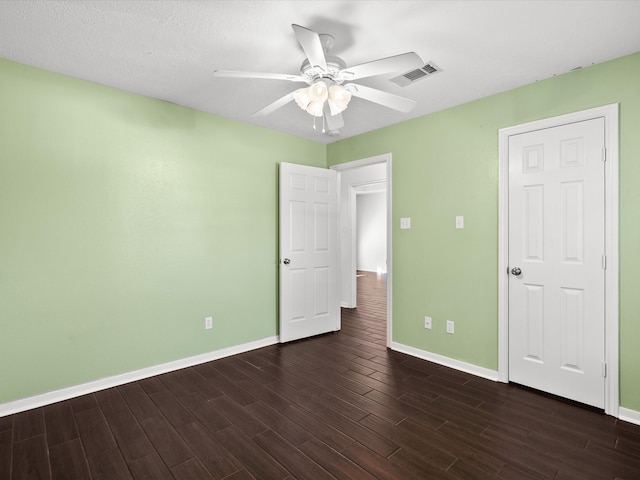 unfurnished bedroom with ceiling fan, a textured ceiling, and dark hardwood / wood-style flooring