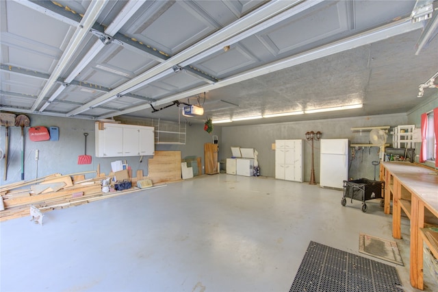 garage with a garage door opener and white refrigerator