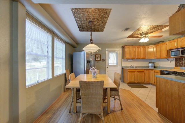 dining room with sink, a wealth of natural light, and light wood-type flooring