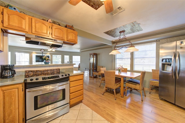 kitchen featuring appliances with stainless steel finishes, ceiling fan, pendant lighting, and light hardwood / wood-style floors