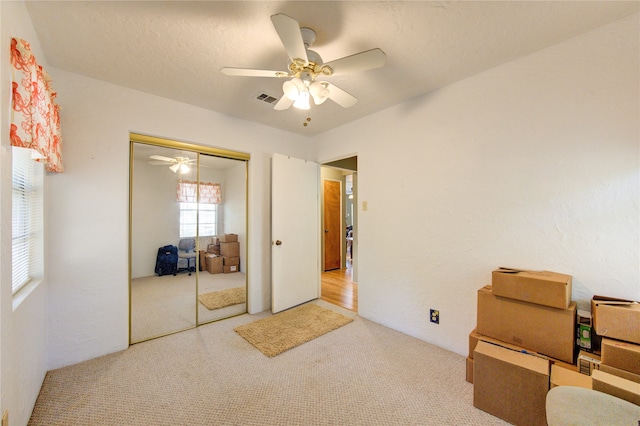 carpeted bedroom featuring a closet and ceiling fan