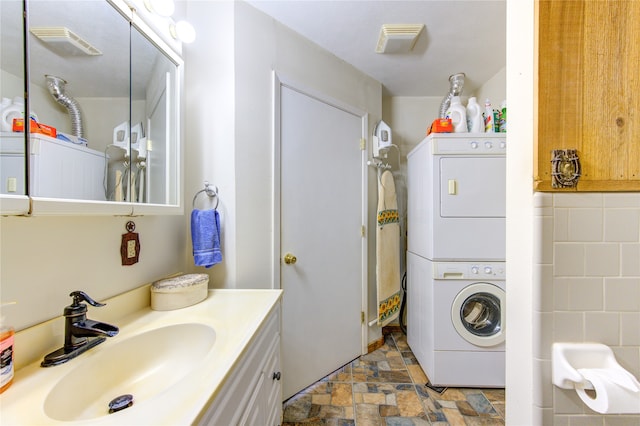 laundry area with sink and stacked washer and clothes dryer