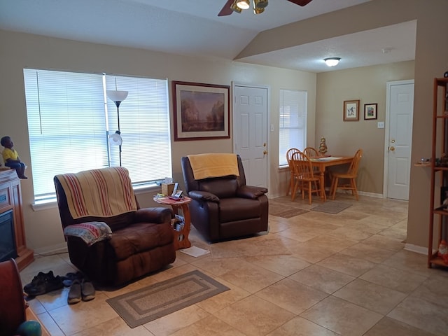 living room featuring lofted ceiling, light tile patterned floors, and ceiling fan