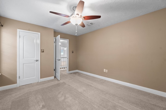 carpeted empty room with a textured ceiling and ceiling fan