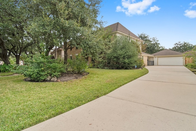 view of property hidden behind natural elements featuring a front yard and a garage