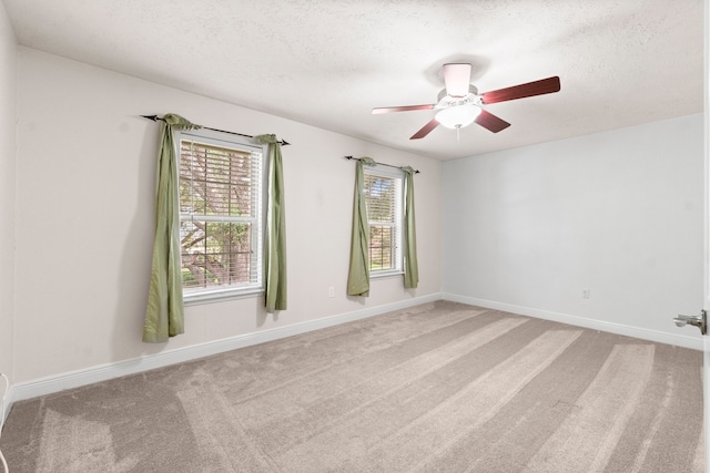 spare room featuring light carpet, a textured ceiling, and ceiling fan