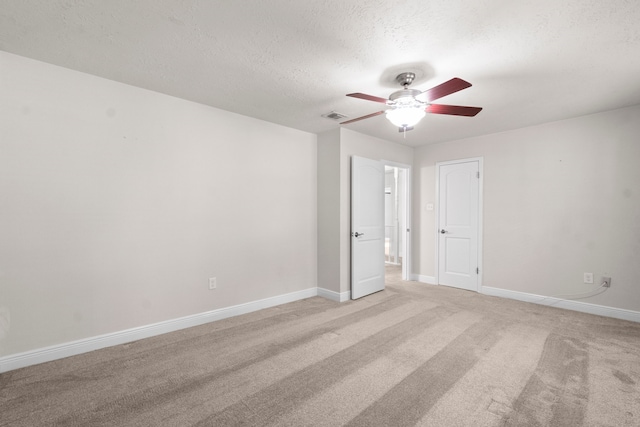 unfurnished room featuring light carpet, a textured ceiling, and ceiling fan