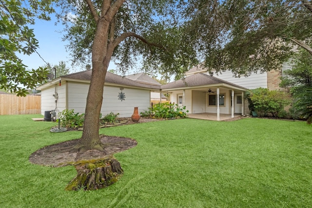 rear view of property with a patio area, a yard, and ceiling fan