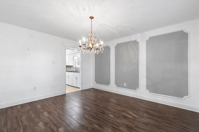 unfurnished dining area featuring an inviting chandelier, sink, and dark hardwood / wood-style flooring