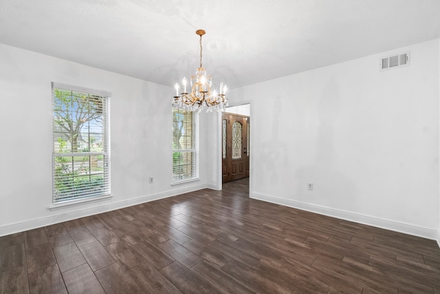 unfurnished dining area with dark wood-type flooring and a notable chandelier