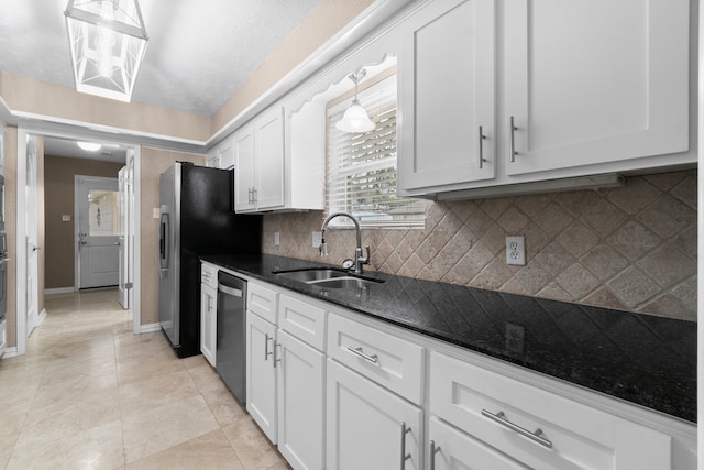 kitchen with tasteful backsplash, sink, stainless steel appliances, pendant lighting, and white cabinets