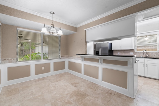 kitchen featuring crown molding, white cabinetry, stainless steel refrigerator with ice dispenser, and an inviting chandelier