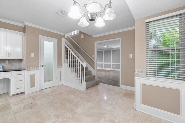 foyer entrance featuring crown molding, a textured ceiling, and a chandelier