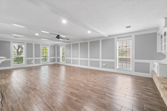 unfurnished living room with a textured ceiling, hardwood / wood-style flooring, and ceiling fan