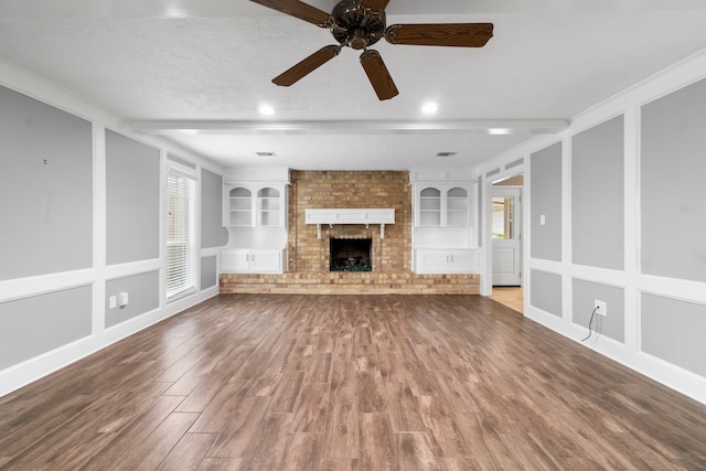 unfurnished living room featuring a textured ceiling, hardwood / wood-style flooring, built in features, and ceiling fan