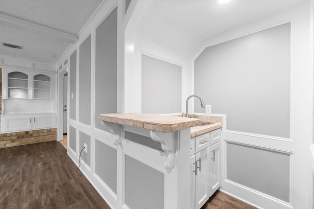 kitchen with white cabinetry, a textured ceiling, sink, and dark hardwood / wood-style floors