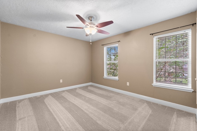 carpeted empty room featuring ceiling fan and a textured ceiling