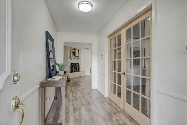 hallway with hardwood / wood-style floors, crown molding, and french doors