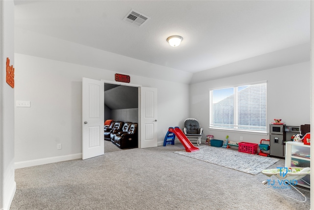 game room featuring carpet and vaulted ceiling