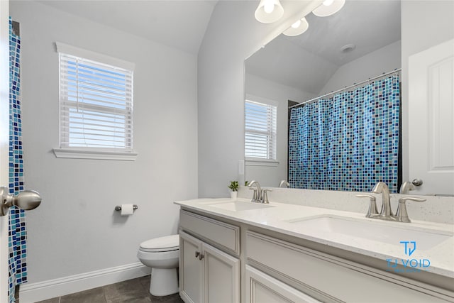 bathroom featuring lofted ceiling, tile patterned floors, toilet, and vanity