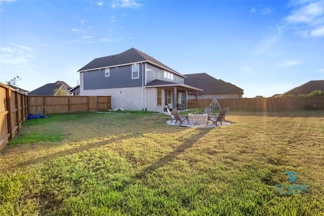 back of property featuring a patio area, a yard, and an outdoor fire pit