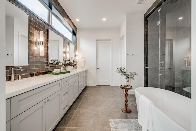 bathroom with backsplash, vanity, and independent shower and bath