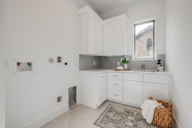 clothes washing area with gas dryer hookup, sink, hookup for a washing machine, hookup for an electric dryer, and light tile patterned flooring