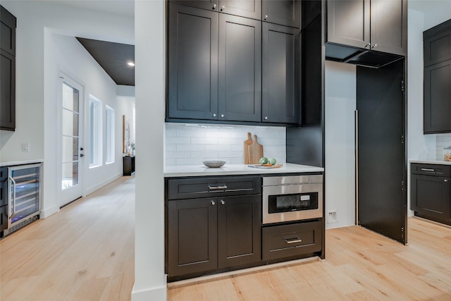 kitchen featuring light hardwood / wood-style flooring, wine cooler, and tasteful backsplash