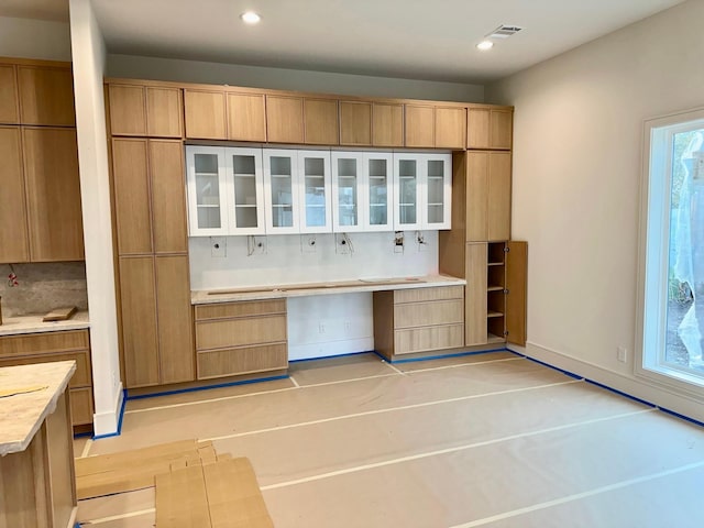 kitchen featuring light brown cabinets and tasteful backsplash