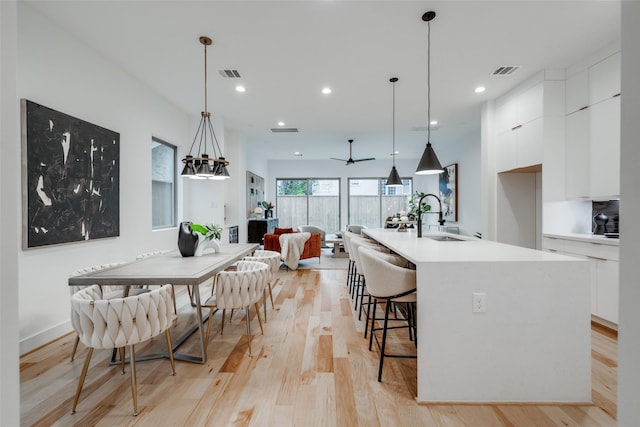 kitchen with visible vents, a sink, light wood-style floors, white cabinetry, and modern cabinets