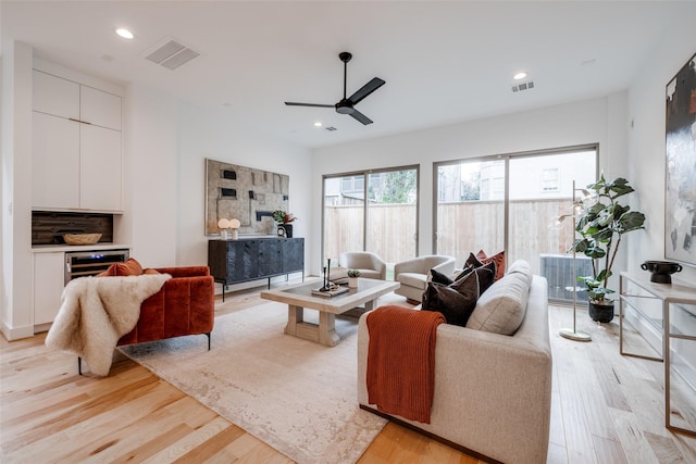 living area with light wood-style flooring, recessed lighting, and visible vents