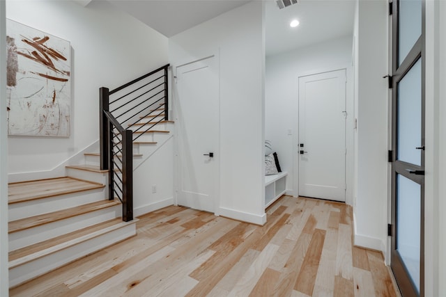 entrance foyer with visible vents, baseboards, stairs, and light wood-style floors