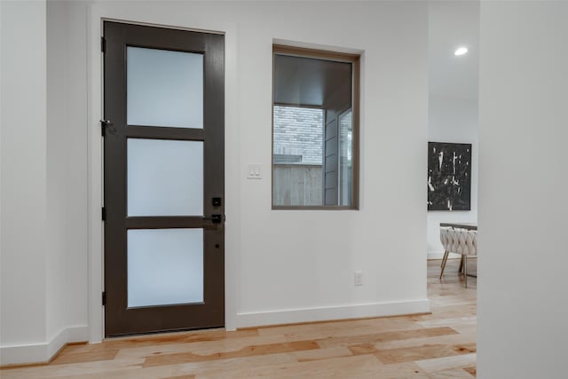 foyer entrance with baseboards and wood finished floors