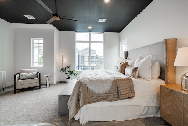 carpeted bedroom featuring radiator, a ceiling fan, visible vents, and baseboards