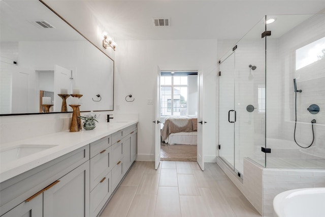 full bathroom with double vanity, a stall shower, visible vents, and a sink