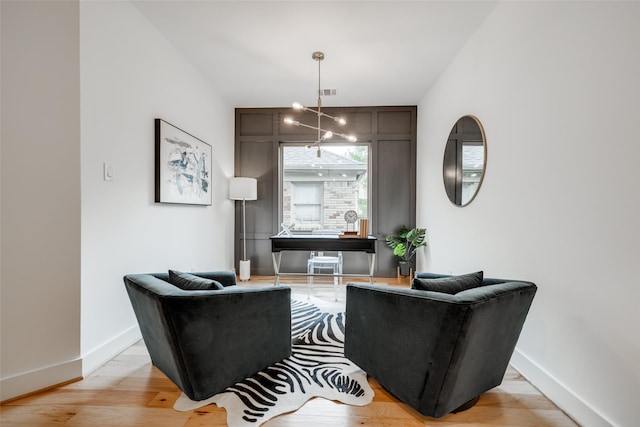 living area with visible vents, baseboards, light wood-style floors, and a chandelier