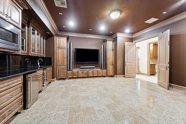 home theater room featuring beverage cooler, crown molding, and wet bar