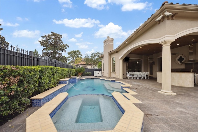 view of swimming pool featuring pool water feature, a patio area, an in ground hot tub, and exterior bar