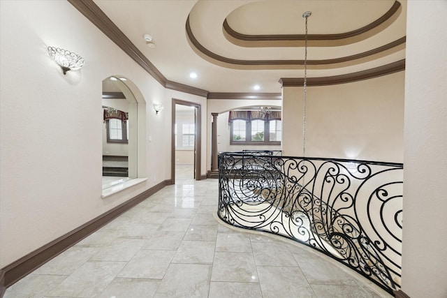 corridor with crown molding and a raised ceiling